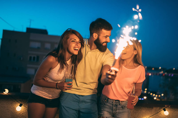Happy group of friends lighting sparklers and enjoying freedom - Φωτογραφία, εικόνα