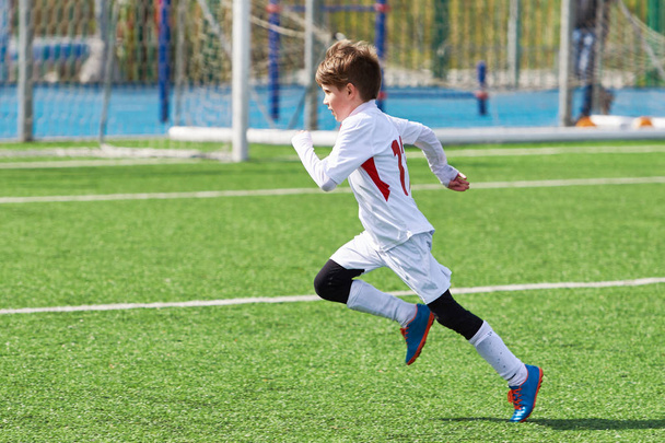 Running boy soccer player training on the football field - Fotó, kép
