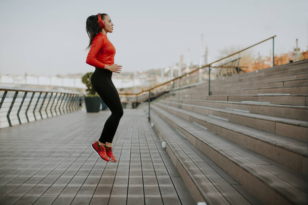 Fitness-Frau springt im Freien in urbaner Umgebung - Foto, Bild