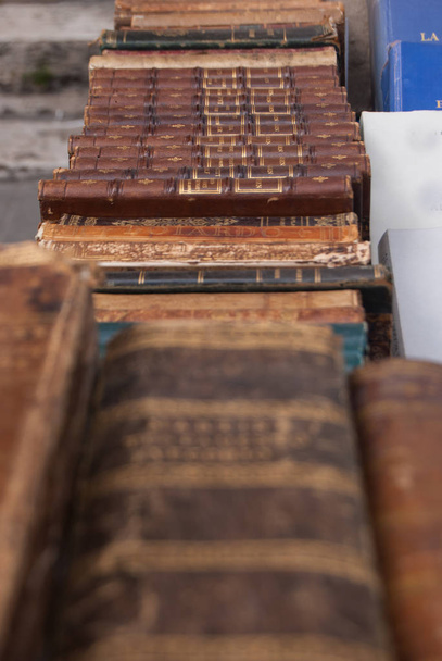 antike braune Bücher, die auf einem Antiquitätenmarkt entlang einer Straße verkauft werden - Foto, Bild
