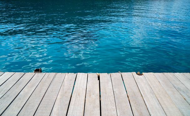 escritorio de madera vacía y fondo marino azul verano.Espacio en blanco para texto e imágenes
. - Foto, Imagen