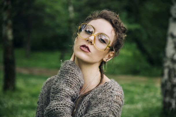 Bella giovane donna con gli occhiali all'aperto nella foresta
 - Foto, immagini