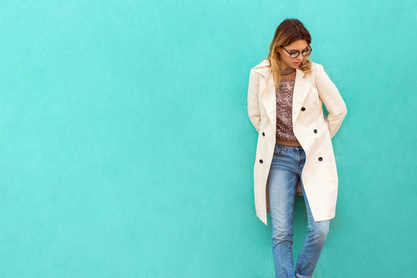 fashion girl in round glasses stands posing near a turquoise wall - Photo, Image