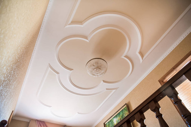 beautiful chandelier on a ceiling with a stucco molding - Φωτογραφία, εικόνα