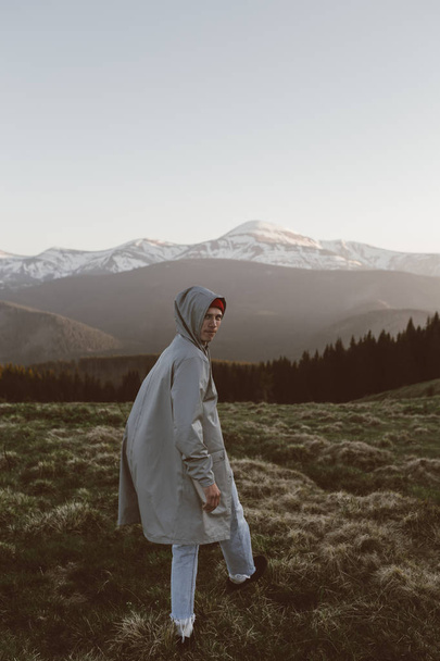 man in gray raincoat on the top of mountain background of mountains - Foto, Imagem