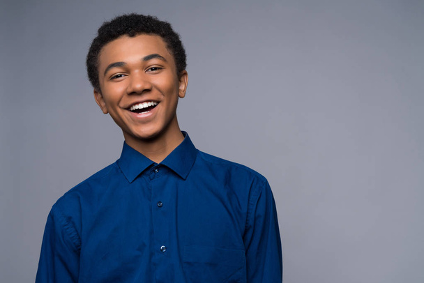 Happy African American teenager in denim shirt. - Фото, изображение