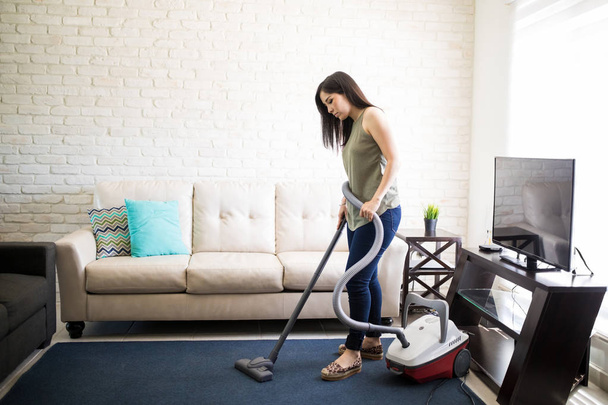Вид збоку виснаженої домогосподарки щодня займається прибиранням будинку
 - Фото, зображення