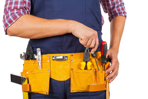 Close up picture of young handyman's yellow tool belt on isolated background - 写真・画像