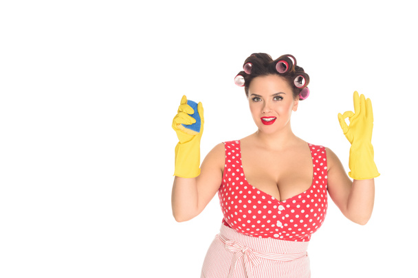 smiling plus size woman in rubber gloves with sponge showing okay gesture isolated on white - Foto, Bild