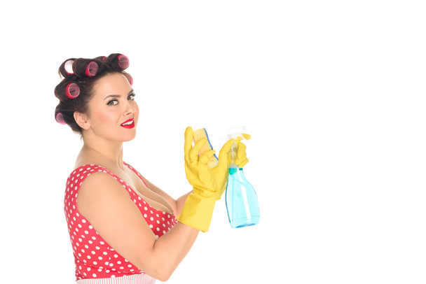 vista lateral da mulher plus size em luvas de borracha com suprimentos de limpeza isolados em branco
 - Foto, Imagem