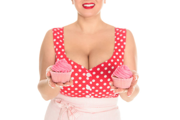 foto recortada de mujer de talla grande con cupcakes de crema rosa aislados en blanco
 - Foto, Imagen