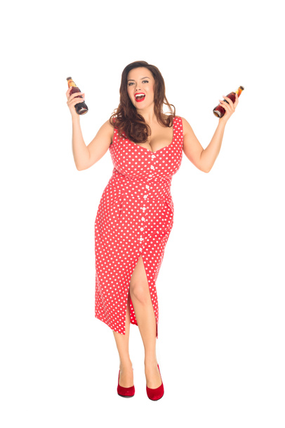 happy plus size woman with bottles of soda looking at camera isolated on white - Photo, Image