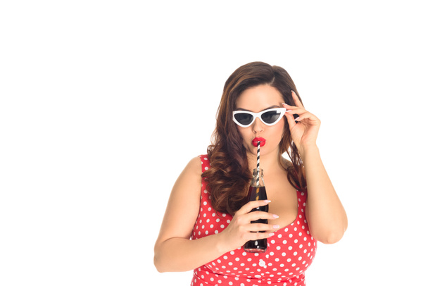 stylish plus size woman in vintage sunglasses drinking soda isolated on white - Photo, Image