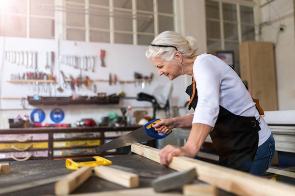 Senior kobieta robi stolarki w warsztacie - Zdjęcie, obraz