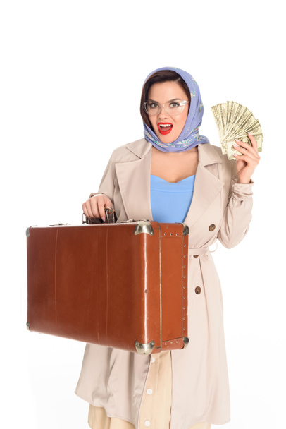 όμορφη νεαρή γυναίκα vintage σε γυαλιά που κρατάτε βαλίτσα και Δολάριο τραπεζογραμμάτια που απομονώνονται σε λευκό - Φωτογραφία, εικόνα