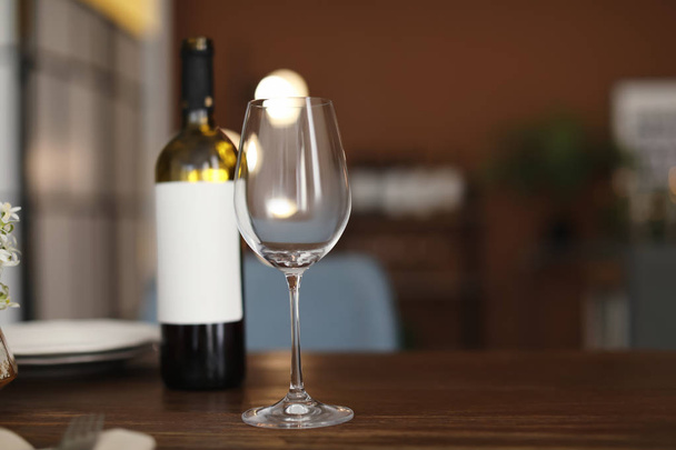 Glass and bottle of wine on table in restaurant - 写真・画像