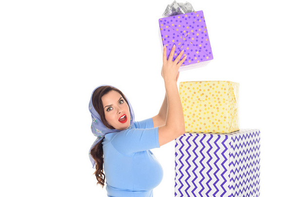 surprised young woman with pile of presents looking at camera isolated on white - Photo, Image