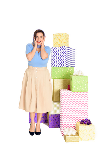 surprised stylish woman standing near gift boxes and looking at camera isolated on white - Φωτογραφία, εικόνα