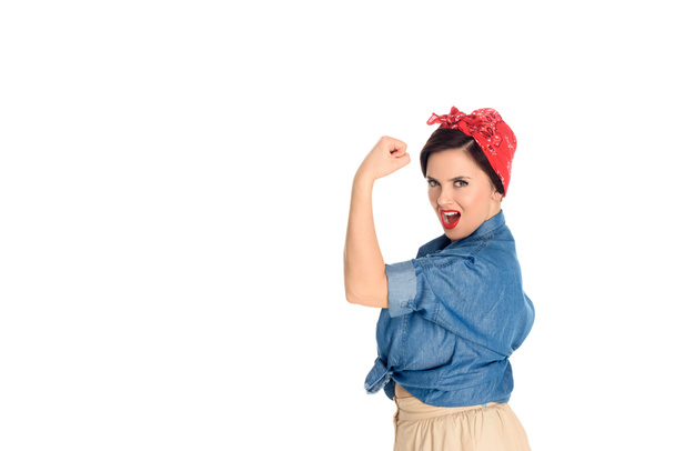 nadšený, pin up žena ukazující biceps a při pohledu na fotoaparát izolované na bílém  - Fotografie, Obrázek