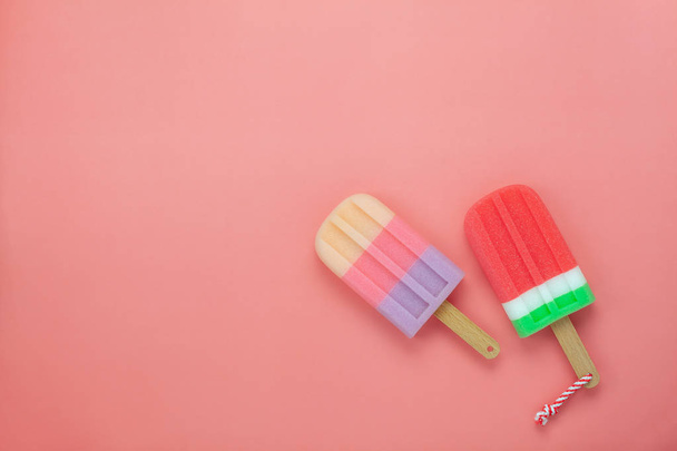 Table top view aerial image of food for summer holiday background concept.Flat lay arrangement variety ice cream pop stick on modern rustic pink paper wallpaper at office desk.Pastel tone design. - Photo, Image