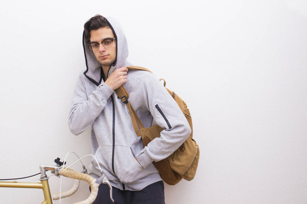 young fashion with backpack and bike on the wall - Photo, Image