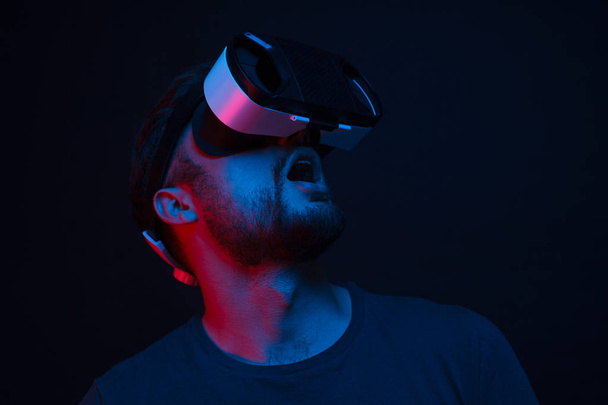 Amazed man in VR glasses looking up - Foto, Imagem