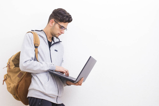 estudiante o adulto joven con portátil en la pared blanca con espacio
 - Foto, Imagen