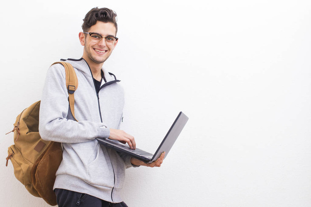 estudante ou jovem adulto com laptop na parede branca com espaço
 - Foto, Imagem
