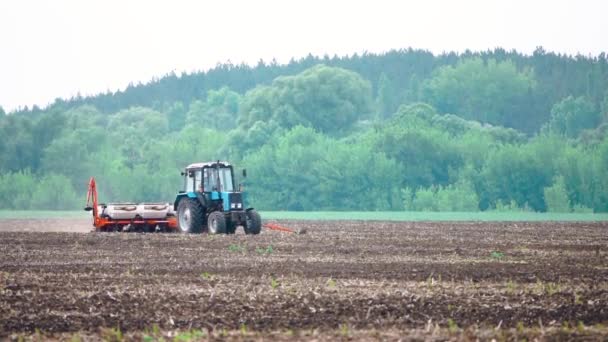 Traktorwerk pflügt das Feld, bevor die Ernte in Zeitlupe gepflanzt wird - Filmmaterial, Video