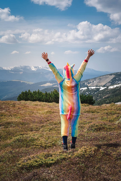 Zábavné cestování, ženské turista v obleku jednorožec slaví úspěch, stojící na vrcholu hory s výhledem na Karpatské krajiny na jarní den. Wanderlust koncept. - Fotografie, Obrázek