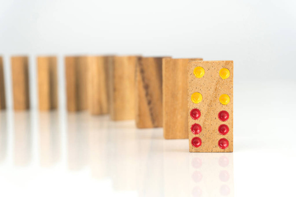 Dominosteine aus Holz stehen in einer Reihe auf weißem Tisch - Foto, Bild