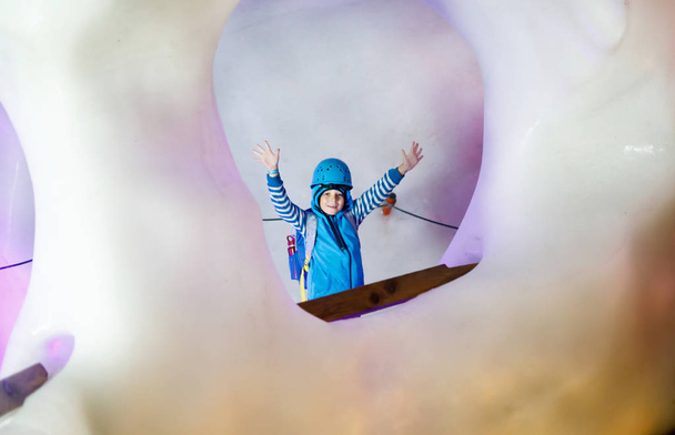 Маленький хлопчик з шоломами безпеки всередині льодовика з льодовим тунелем. Шкільний хлопчина, який подорожує і знаходить гору в Тіролі (Австрія).. - Фото, зображення