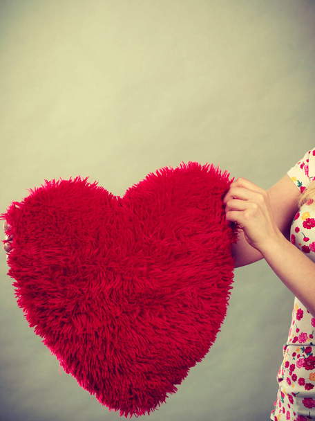 Woman hand holding heart shaped pillow. Valentines day, love gift ideas concept. - Fotoğraf, Görsel