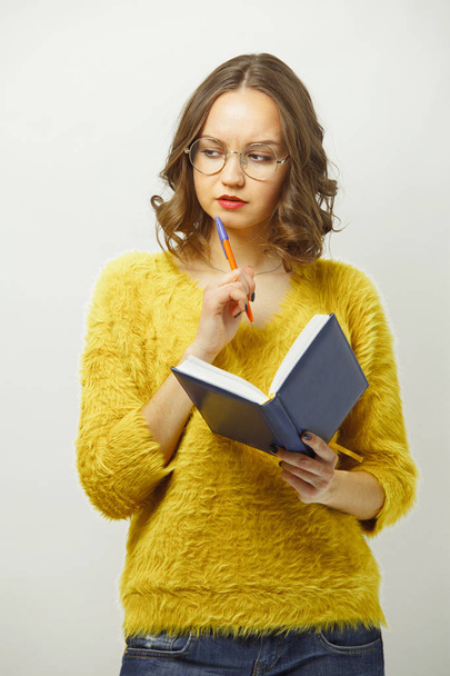 Isolated portrait of young woman with thoughtful face thinks what to write in diary. - Photo, image