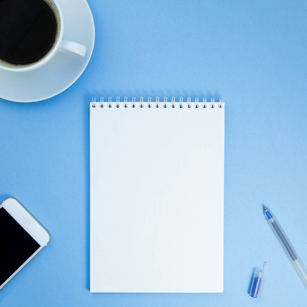 kreative quadratische flache Lay-Foto des Arbeitsplatzes Schreibtisch mit Papier Notizbuch, Smartphone, Stift und Kaffee mit Kopierraum Hintergrund minimalen Stil - Foto, Bild