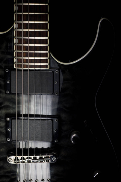 Body of a modern electric black guitar. Close-up photo with light painting technique. - Foto, Imagen