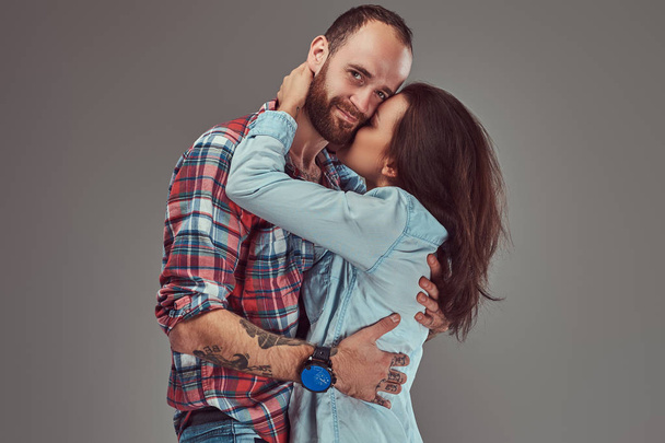 Attractive couple, bearded man and brunette girl cuddling in a studio. - Photo, Image