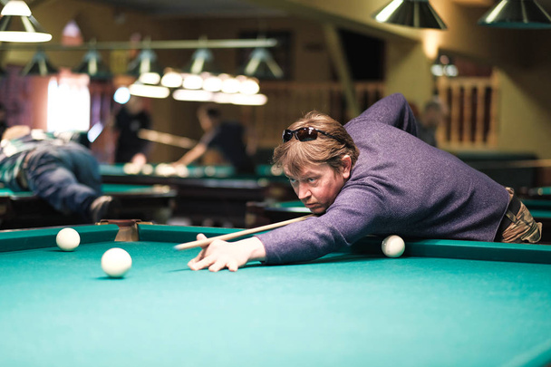 a pool player takes aim at the ball - Foto, Imagen