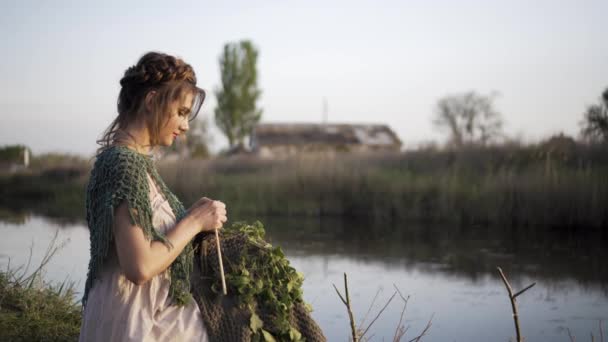 Tricô mão mulher fazendo tecido de lã. menina está sentado no lago
 - Filmagem, Vídeo