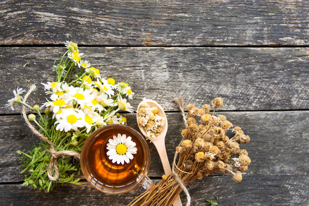 šálek bylinné Heřmánkový čaj s čerstvým daisy květiny na dřevěné pozadí. lékař léčbu a prevenci imunní konceptu, lékařství - folk, alternativní, doplňkové, tradiční medicína  - Fotografie, Obrázek