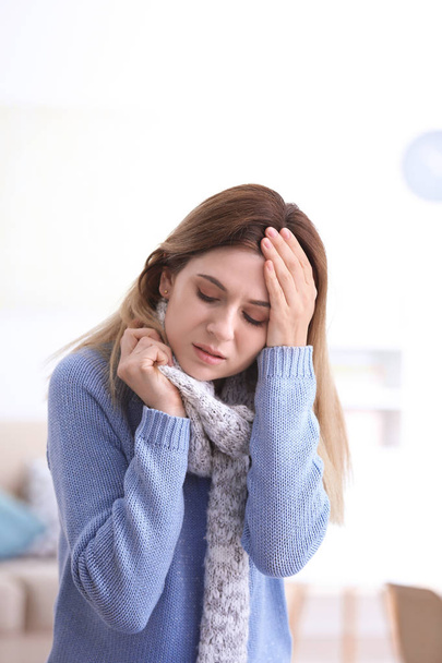 Woman with headache suffering from cold on blurred background - Фото, изображение
