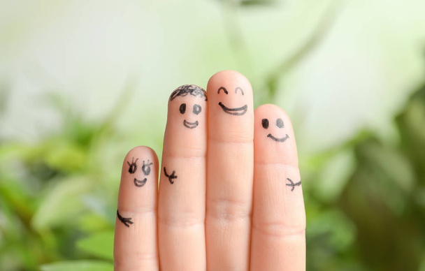 Fingers with drawings of happy faces against blurred background. Unity concept - Фото, изображение