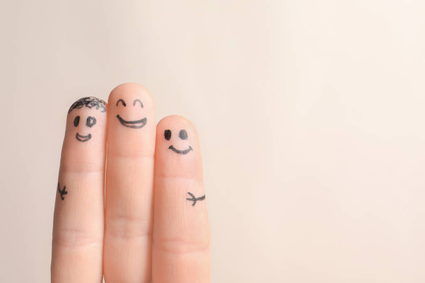 Fingers with drawings of happy faces against light background. Unity concept - Photo, image