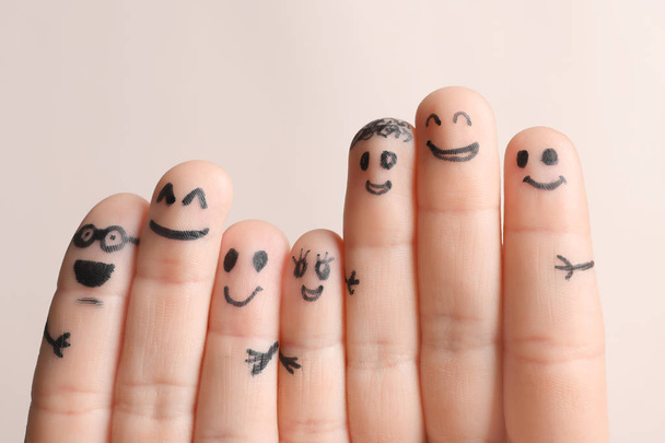Fingers with drawings of happy faces against light background. Unity concept - Фото, изображение