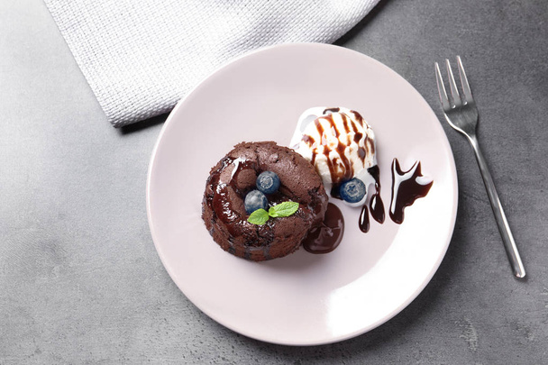Plate of delicious fresh fondant with hot chocolate and blueberries on table, top view. Lava cake recipe - Foto, Imagem
