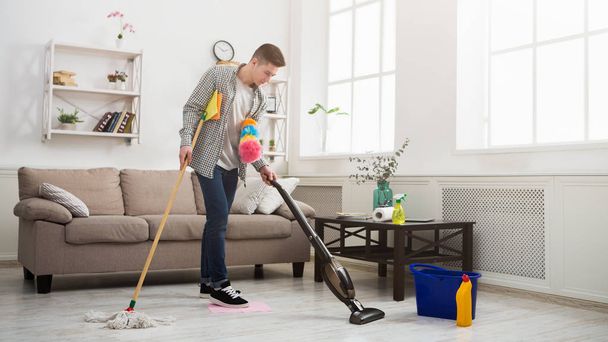 Junger Mann putzt Haus mit vielen Werkzeugen - Foto, Bild