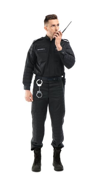 Male security guard using portable radio transmitter on white background - Foto, Bild