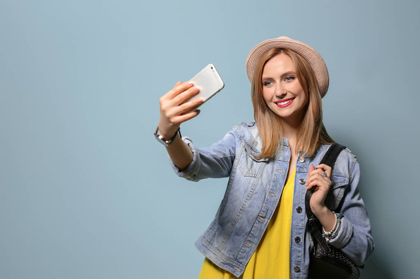 Attractive young woman taking selfie on color background - Photo, image