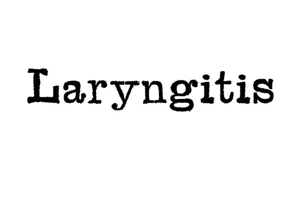 Het woord Laryngitis van een schrijfmachine op een witte achtergrond - Foto, afbeelding