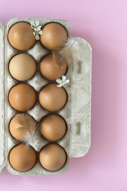 Flat-lay of eggs and blossom over light pink pastel background, top view with space for your text - Fotó, kép